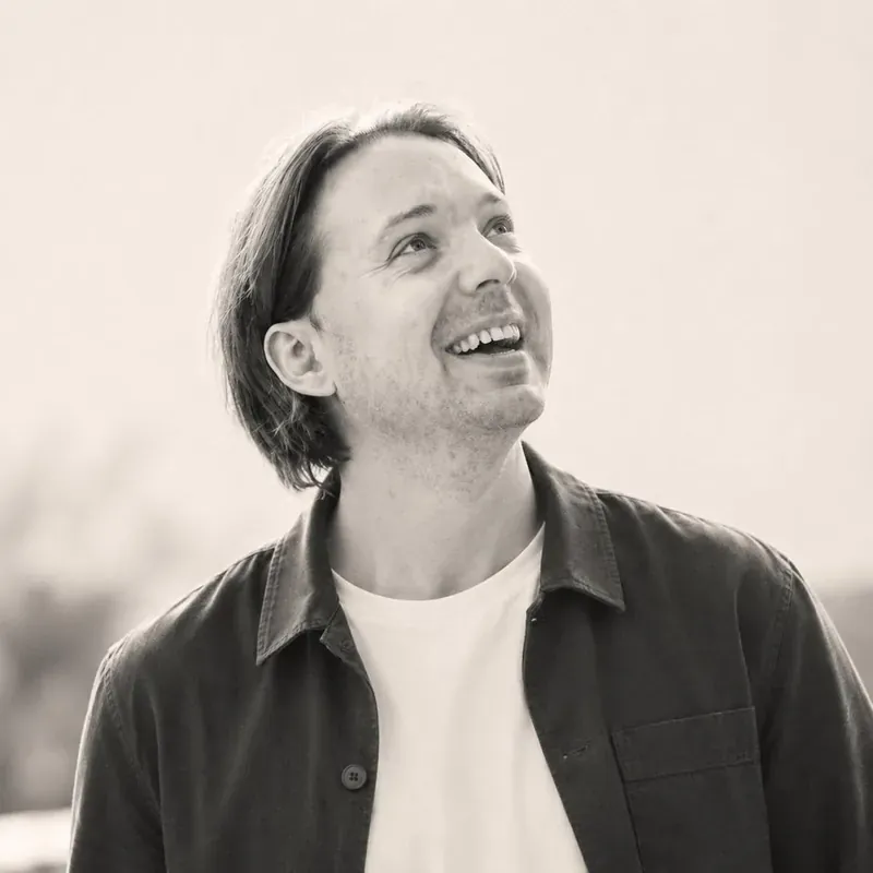 Philipp Weigert, Gründer von WYKING, lachend im Freien, Schwarz-Weiß-Porträt